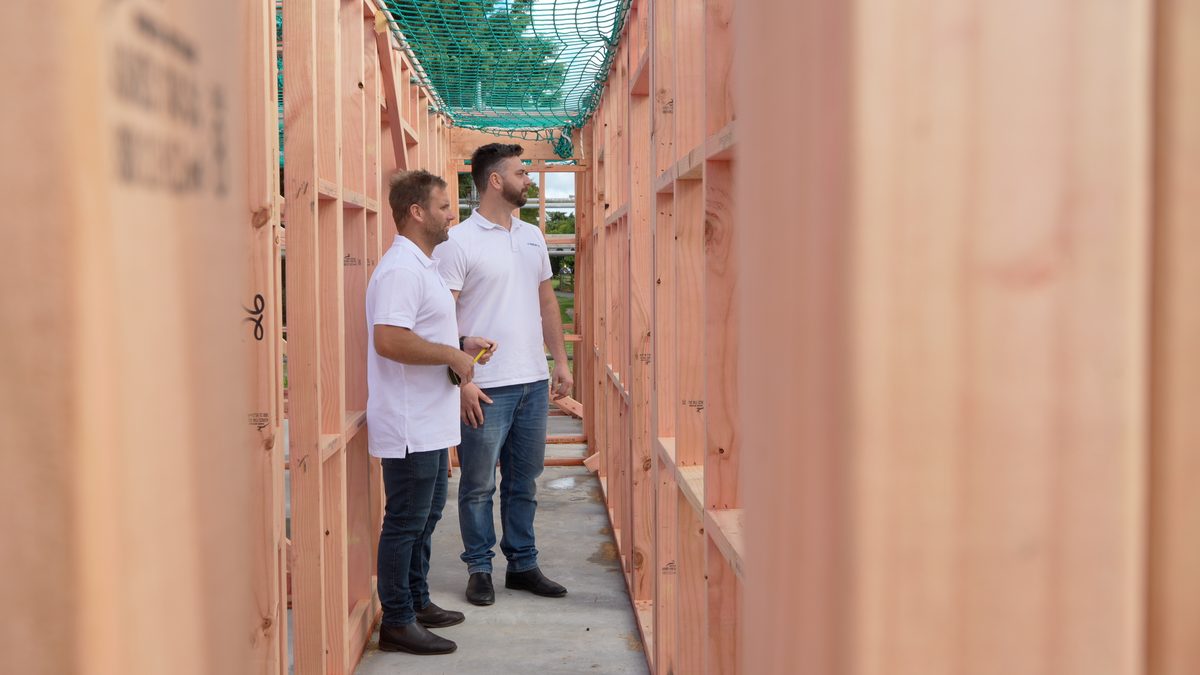 Cole and Brad from TakeoffQS inspecting a timber frame on a building site